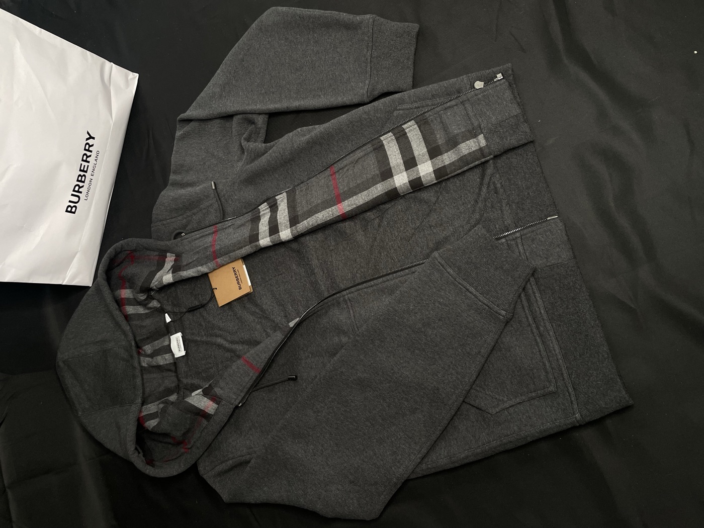 Capuche Burberry avec sa doublure check, son sac et son étiquette